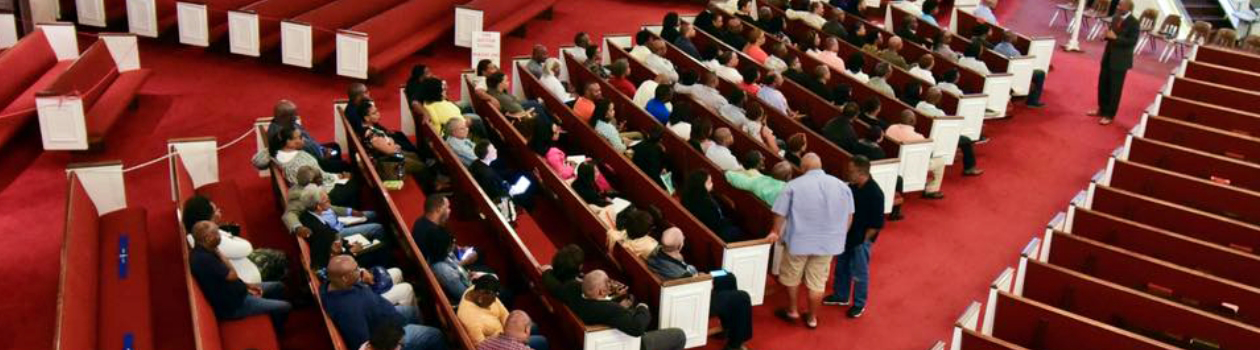 A crowd of people sitting in pews at Mount Olive Baptist Church in Arlington, Texas.