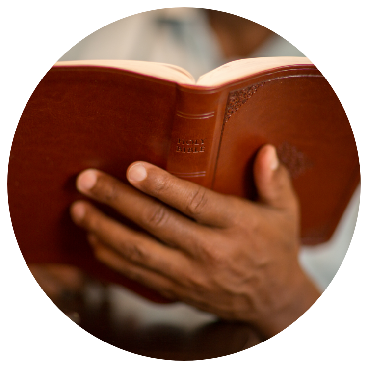 A man's hands holding a Bible in an African American Baptist Church.